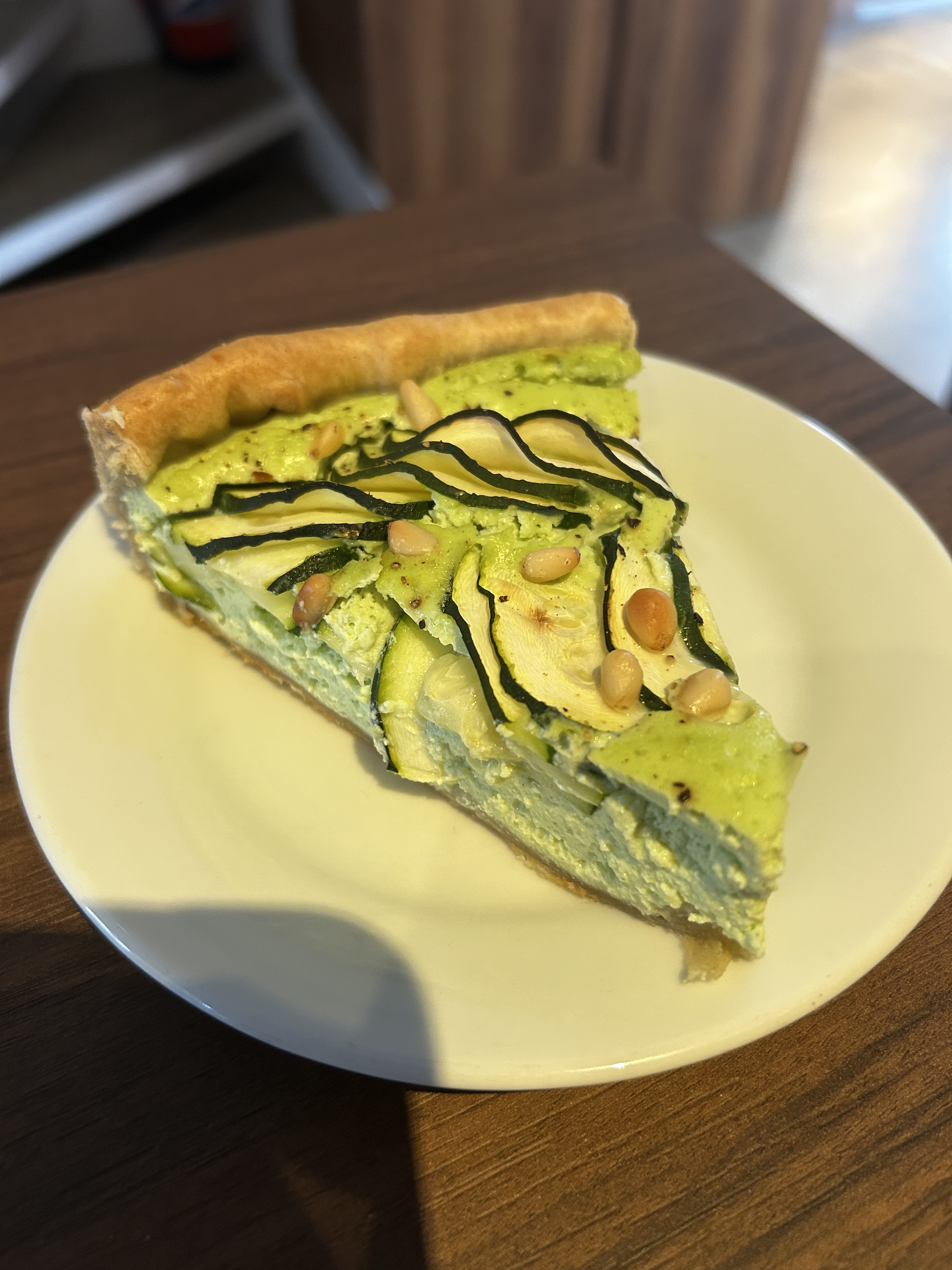 Part de quiche aux courgettes maison servie sur une assiette